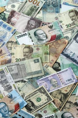 Farklı para birimlerinden bir sürü banknot. Rastgele para akışının arka planı kapanıyor.