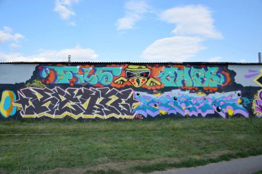 Sokak sanatı kültürü tarzında boya lekeleriyle süslenmiş eski duvar. Duvarında parlak aerosol çizgileri olan graffiti resimlerinin renkli arka planı. Renkli arkaplan dokusu