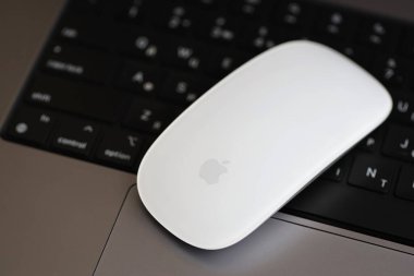 KYIV, UKRAINE - 27 Kasım 2023 Apple Magic Mouse 3. Nesil Gri MacBook 2021 ile yakın plan
