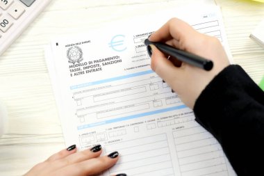 KYIV, UKRAINE - 31 Ekim 2023 Muhasebeci İtalyan vergi formu F23 Ödeme model vergisi vergileri cezaları ve vergi döneminin sonunda diğer gelirleri doldurdu. İtalya 'da vergi ve evrak işleri rutini