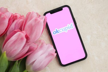 KYIV, UKRAINE - FEBRUARY 23, 2024 Okcupid logo of famous dating website or app on iPhone display screen close up clipart