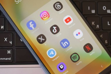 KYIV, UKRAINE - Galaksi A04 'te 28 Şubat 2024 Sosyal Medya simgeleri grubu MacBook klavyesinde akıllı telefon görüntüsü