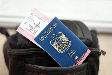 Mavi Birleşik Arap Emirlikleri pasaportu ve turistik sırt çantasında uçak biletleri. Turizm ve seyahat kavramı