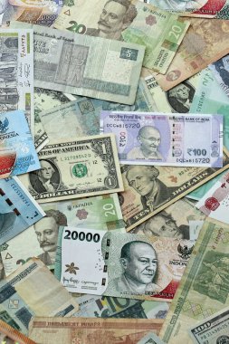 Farklı para birimlerinden bir sürü banknot. Rastgele para akışının arka planı kapanıyor.