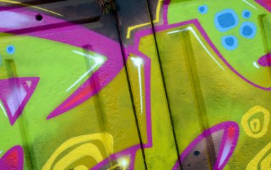 Duvarında parlak aerosol çizgileri olan grafiti resimlerinin renkli arka planı. Eski moda sokak sanatı sprey boya kutularından yapılmış. Çağdaş gençlik kültürü arka planı