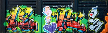 Sokak sanatı kültürü tarzında boya lekeleriyle süslenmiş eski duvar. Duvarında parlak aerosol çizgileri olan graffiti resimlerinin renkli arka planı. Renkli arkaplan dokusu