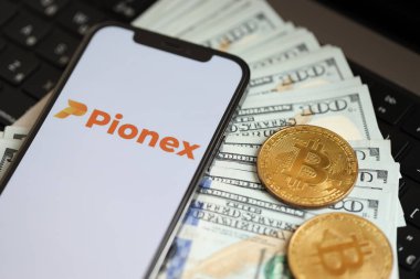 KYIV, UKRAINE - 15 Mart 2024 Pionex logosu iPhone ekranında dolar ve bitcoin ile MacBook. Kripto döviz portalı