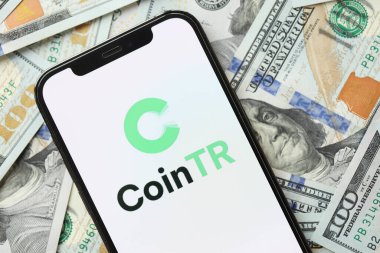 KYIV, UKRAINE - 15 Mart 2024 'te iPhone ekranında yüz dolarlık banknotlarla CoinTR logosu. Kripto döviz portalı