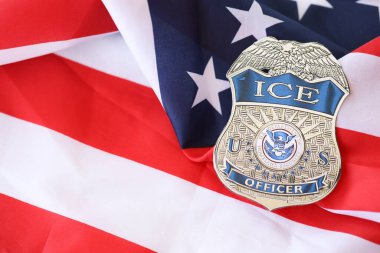 KYIV, UKRAINE - 9 Mart 2024 ABD göçmen bürosu rozeti Amerika Birleşik Devletleri bayrağına yakın