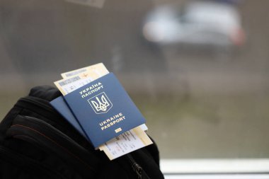 Siyah turistik sırt çantası üzerinde uçuş biletleri olan iki Ukrayna biyometrik pasaportu.