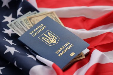 Ukrayna 'nın biyometrik pasaportu ve Amerika Birleşik Devletleri' nin el sallayan bayrağı üzerindeki Amerikan dolarları kapanıyor.