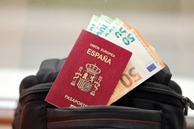 Avrupa Birliği 'nin turistik sırt çantasında para ve uçak biletleriyle kırmızı İspanyol pasaportu. Turizm ve seyahat kavramı