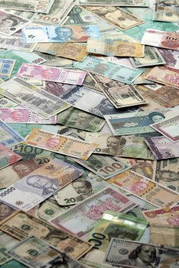 Farklı para birimlerinden bir sürü banknot. Rastgele para akışının arka planı kapanıyor.