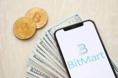 KYIV, UKRAINE - 15 Mart 2024 Bitmart logosu iPhone ekranında dolar ve bitcoin ile birlikte. Kripto döviz portalı