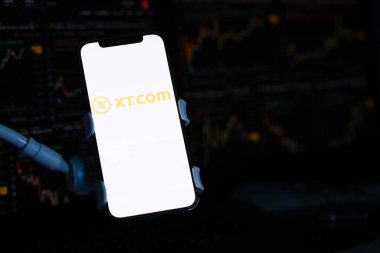 KYIV, UKRAINE - iPhone ekranında 15 Mart 2024 XTcom logosu ve kripto para birimi değer grafikleri. Kripto döviz portalı
