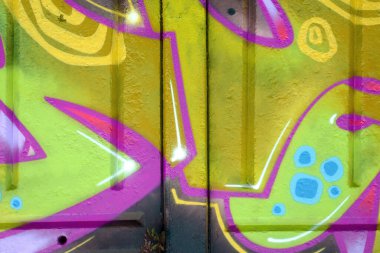Duvarında parlak aerosol çizgileri olan grafiti resimlerinin renkli arka planı. Eski moda sokak sanatı sprey boya kutularından yapılmış. Çağdaş gençlik kültürü arka planı