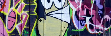 Duvarında parlak aerosol çizgileri olan grafiti resimlerinin renkli arka planı. Eski moda sokak sanatı sprey boya kutularından yapılmış. Çağdaş gençlik kültürü arka planı