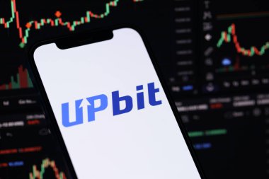 KYIV, UKRAINE - iPhone ekran üzerindeki 15 Mart 2024 Upbit logosu ve kripto para birimi değer grafikleri. Kripto döviz portalı
