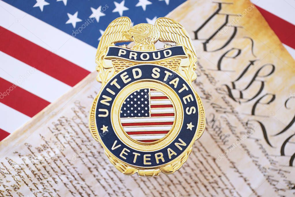 KYIV, UKRAINE - MARCH 9, 2024 US Proud Veteran badge with United States Constitution on flag close up