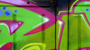 Duvarında parlak aerosol çizgileri olan grafiti resimlerinin renkli arka planı. Eski moda sokak sanatı sprey boya kutularından yapılmış. Çağdaş gençlik kültürü arka planı
