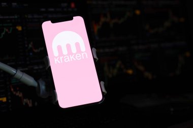 KYIV, UKRAINE - iPhone ekranında 15 Mart 2024 Kraken logosu ve kripto para birimi değer grafikleri. Kripto döviz portalı