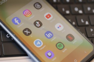 KYIV, UKRAINE - Galaksi A04 'te 28 Şubat 2024 Sosyal Medya simgeleri grubu MacBook klavyesinde akıllı telefon görüntüsü