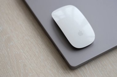 KYIV, UKRAINE - 27 Kasım 2023 Apple Magic Mouse 3. Nesil Gri MacBook 2021 ile yakın plan