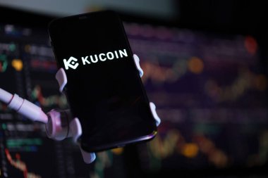 KYIV, UKRAINE - iPhone ekranında 15 Mart 2024 Kucoin logosu ve kripto para birimi değer tabloları. Kripto döviz portalı