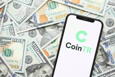 KYIV, UKRAINE - 15 Mart 2024 'te iPhone ekranında yüz dolarlık banknotlarla CoinTR logosu. Kripto döviz portalı