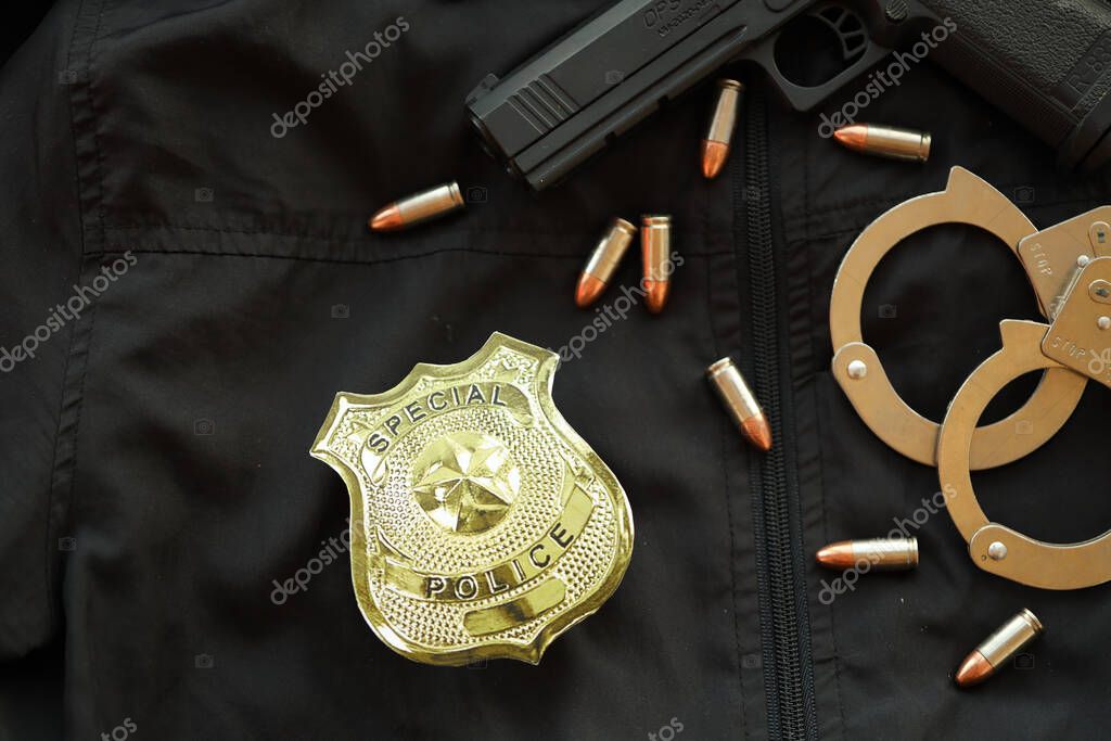 KYIV, UKRAINE - MARCH 9, 2024 US Special Police badge on black jacket uniform with gun, bullets and handcuffs close up