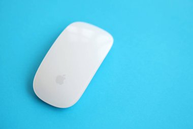 KYIV, UKRAINE - 27 Kasım 2023 Apple Magic Mouse 3. nesil parlak renkli arkaplanda uzanır