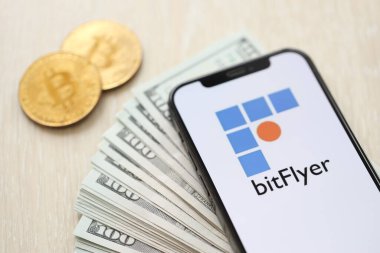 KYIV, UKRAINE - 15 Mart 2024 Btflyer logosu iPhone ekranında dolar ve bitcoin ile birlikte. Kripto döviz portalı