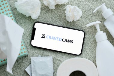 KYIV, UKRAINE - JANUARY 23, 2024 CravedCams adult content website logo on display of iPhone 12 Pro smartphone clipart