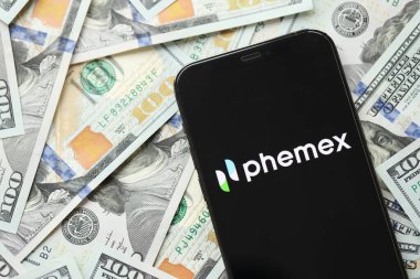 KYIV, UKRAINE - 15 Mart 2024 Phemex logosu iPhone ekranında yüzlerce dolarlık banknotlarla. Kripto döviz portalı