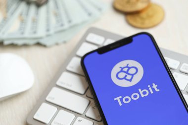 KYIV, UKRAINE - 15 Mart 2024 Toobit logosu iPhone ekranında beyaz klavyede para ve bitcoin ile. Kripto döviz portalı
