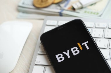 KYIV, UKRAINE - 15 Mart 2024 Bybit logosu iPhone ekranında beyaz klavyede para ve bitcoin ile. Kripto döviz portalı