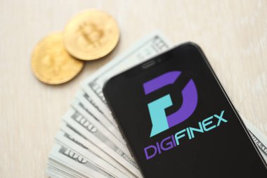 KYIV, UKRAINE - 15 Mart 2024 Digifinex logosu iPhone ekranında dolar ve bitcoin ile. Kripto döviz portalı
