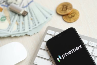 KYIV, UKRAINE - 15 Mart 2024 Phemex logosu iPhone ekranında para ve bitcoin ile birlikte beyaz klavyede. Kripto döviz portalı