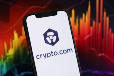 KYIV, UKRAINE - iPhone ekranında 15 Mart 2024 Kripto com logosu ve kripto para birimi değer grafikleri. Kripto döviz portalı