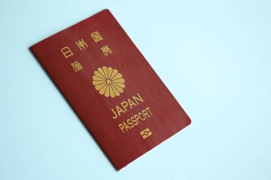 Japon pasaportu mavi arka planda, yakın plan. Turizm ve vatandaşlık kavramı