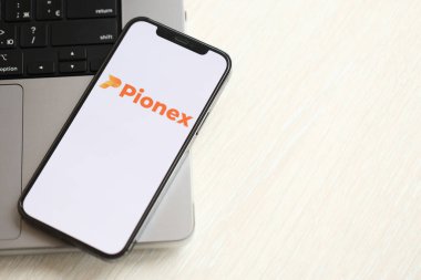 KYIV, UKRAINE - 15 Mart 2024 Pionex logosu MacBook panelinde iPhone ekranında. Kripto döviz portalı