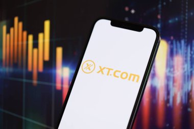 KYIV, UKRAINE - iPhone ekranında 15 Mart 2024 XTcom logosu ve kripto para birimi değer grafikleri. Kripto döviz portalı