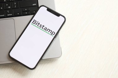 KYIV, UKRAINE - 15 Mart 2024 Bitstamp logosu MacBook panelinde iPhone ekranında. Kripto döviz portalı