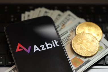 KYIV, UKRAINE - 15 Mart 2024 Azbit logosu iPhone ekranında dolar ve bitcoin ile MacBook 'ta. Kripto döviz portalı
