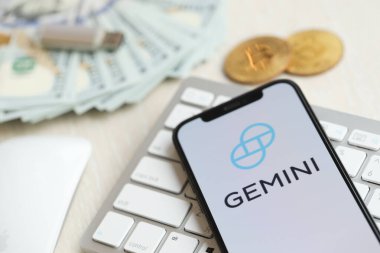 KYIV, UKRAINE - 15 Mart 2024 Gemini logosu iPhone ekranında beyaz klavyede para ve bitcoin ile. Kripto döviz portalı