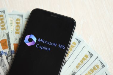 KYIV, UKRAINE - 17 Mart 2024 Microsoft Copilot logosu iPhone ekranında yüzlerce dolarlık banknotlarla. Yapay Zeka Motoru