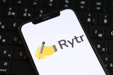 KYIV, UKRAINE - 17 Mart 2024 Rytr logosu iPhone ekranda ve MacBook klavyesinde. Yapay Zeka Motoru