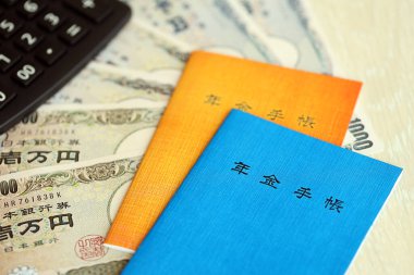 Japon emeklilik sigortası broşürleri yeni para faturaları ve hesap makineleri ile masaya yakın.
