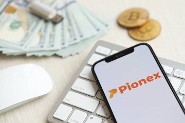 KYIV, UKRAINE - 15 Mart 2024 Pionex logosu iPhone ekranında beyaz klavyede para ve bitcoin ile. Kripto döviz portalı