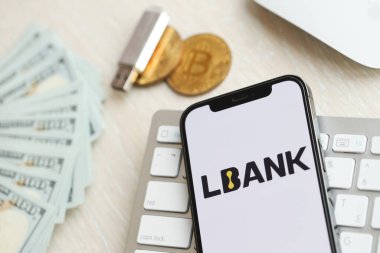 KYIV, UKRAINE - 15 Mart 2024 Lbank logosu iPhone ekranında beyaz klavyede para ve bitcoin ile. Kripto döviz portalı